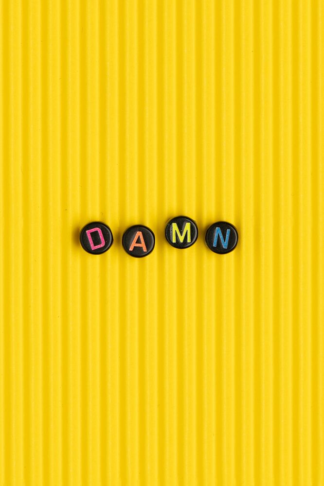 DAMN beads text typography on yellow