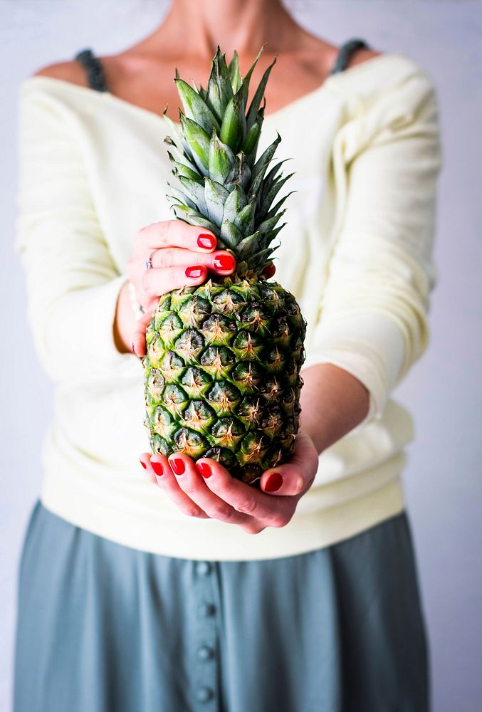 Woman holding organic pineapple tropical fruit