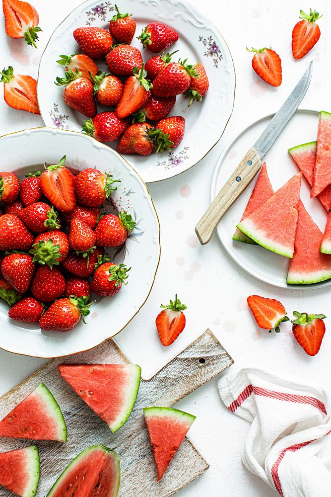 Strawberry and cut watermelon on white table flat lay