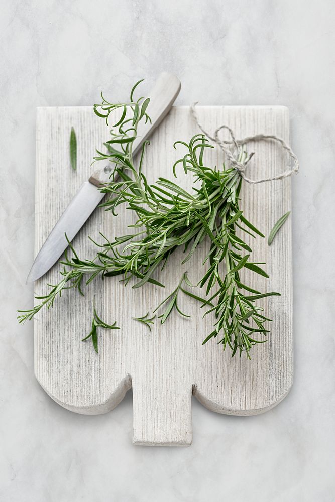 Rosemary leaves psd on cut board flat lay