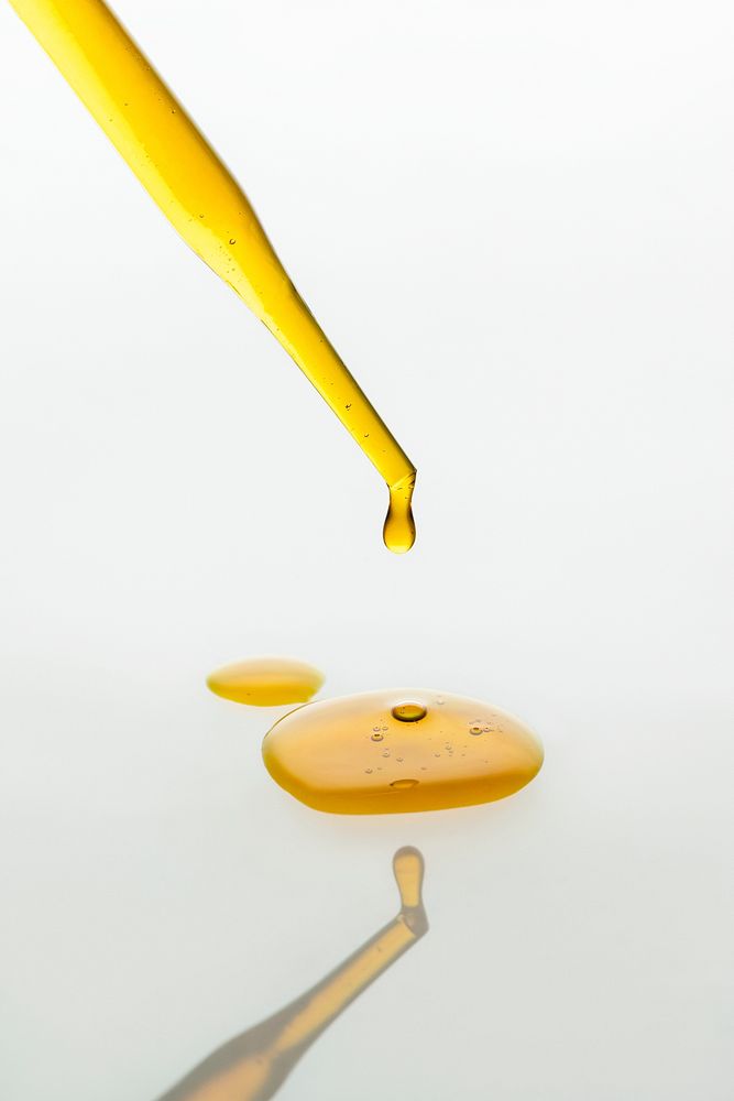 Oil dropper background,  yellow dripping cosmetic product wallpaper