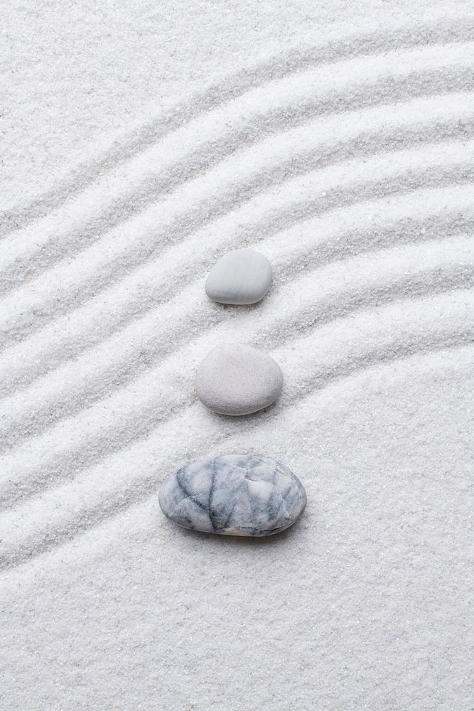 Zen stones white sand background in art of balance concept