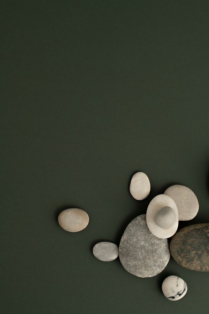 Marble zen stones stacked on green background in health and wellbeing concept
