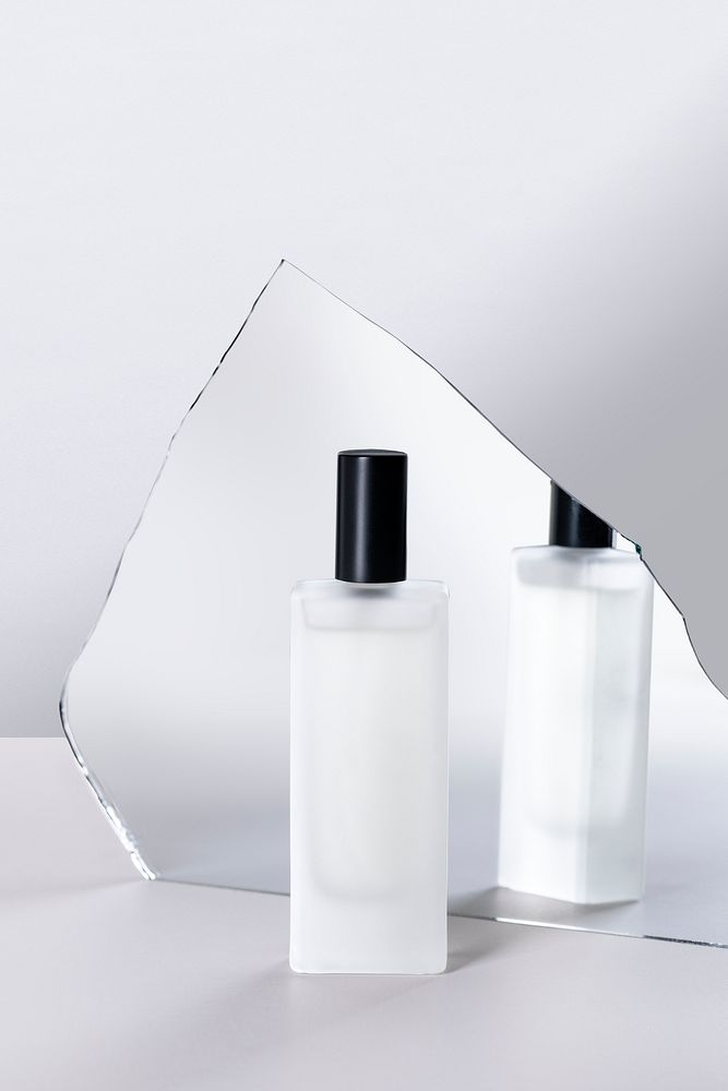 Cosmetic bottle in front of broken mirror