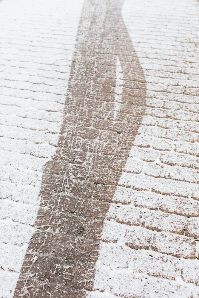Skid marks on a an icy cobblestone road background