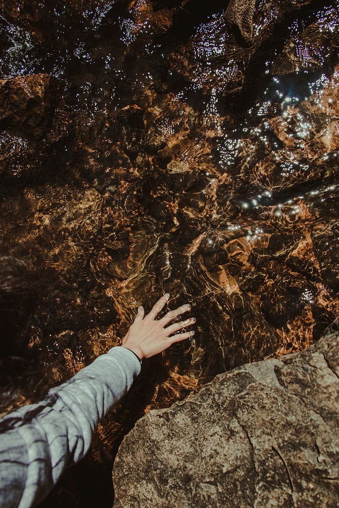 Free hiker touching water image, public domain adventure CC0 photo.