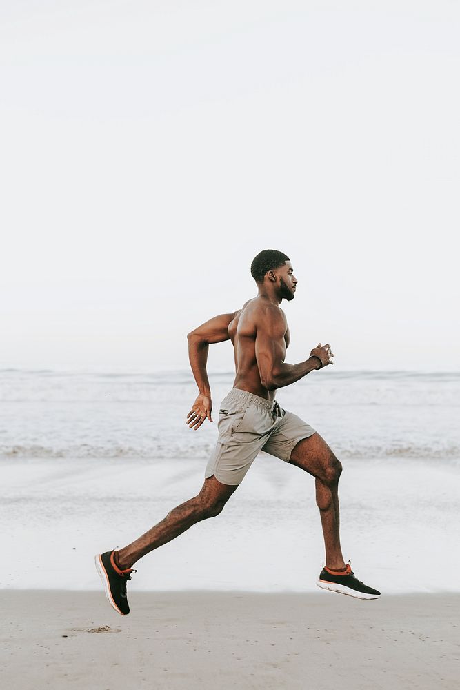 Fit man running at the beach in the early morning