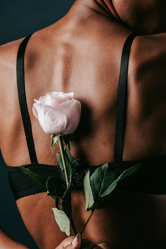 Pink rose behind woman's back