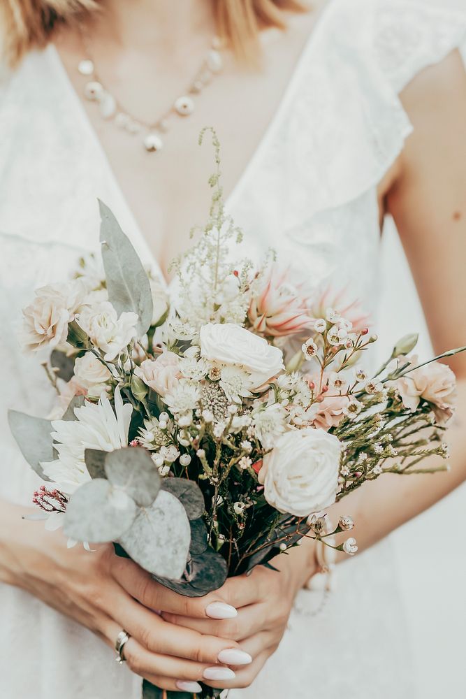 Woman in white dress holding flower bouquet