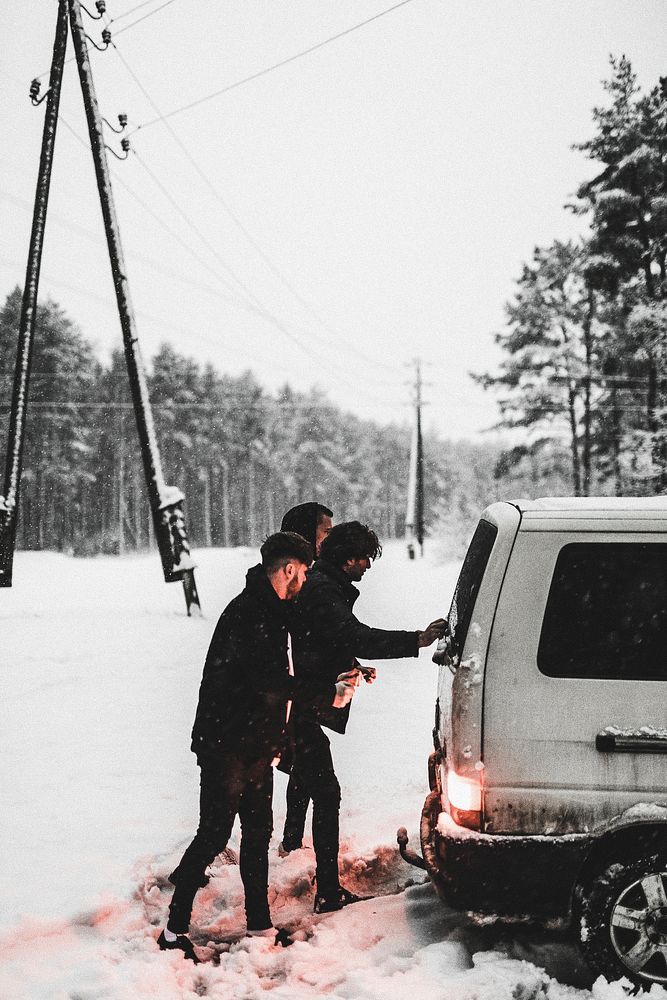 Men pushing van from snow