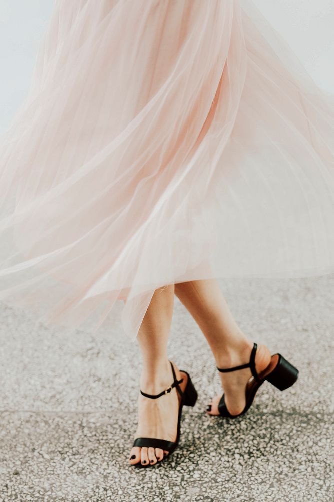 Woman in a pink chiffon skirt dancing on a granite floor