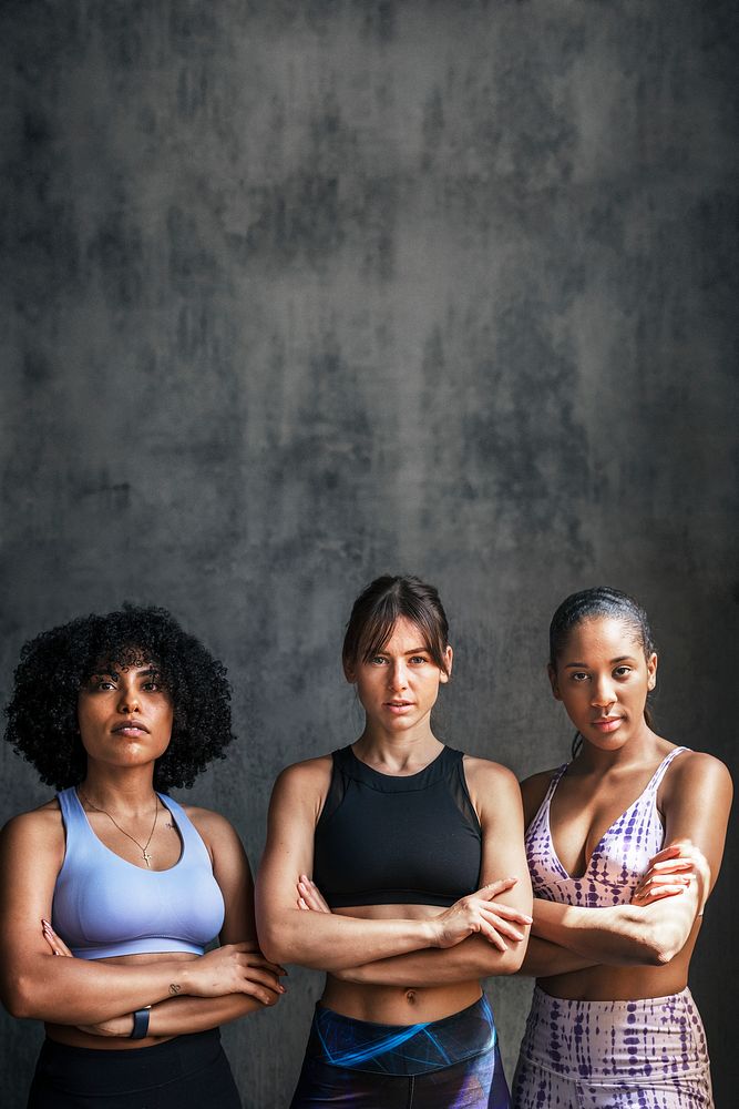 Sportive female personal coaches standing with arms crossed