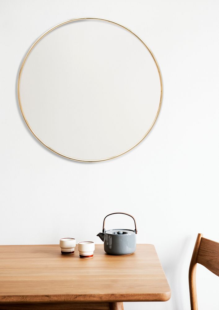 Golden frame on a white wall by a tea set
