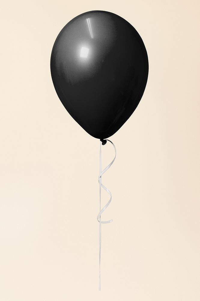 Black single floating balloon on a cream background