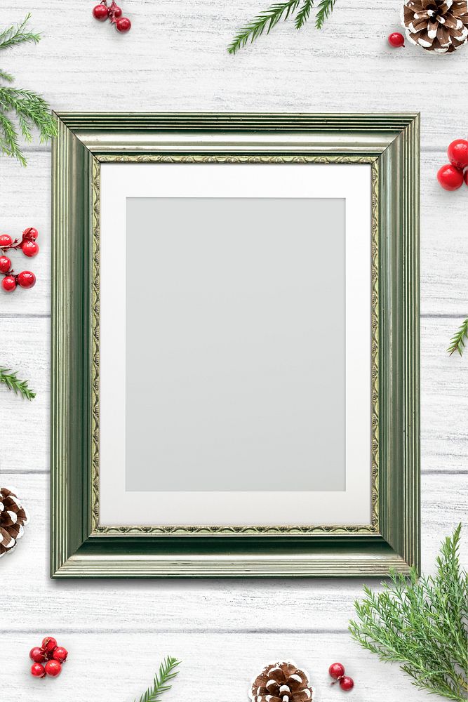 Classic green frame mockup with Christmas decorations on white wooden background