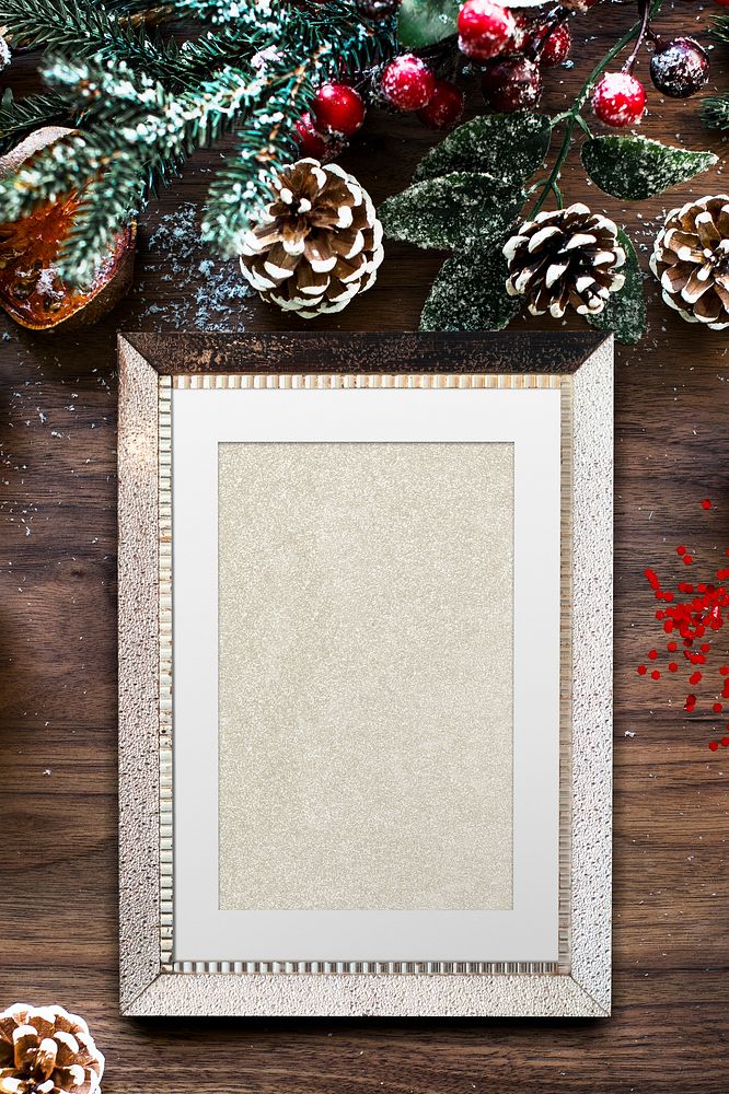 Silver frame mockup with Christmas decorations on wooden background