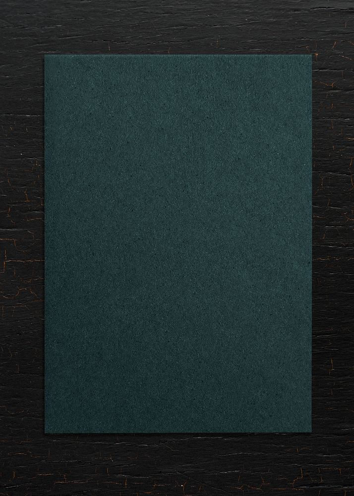 Green paper on a wooden background