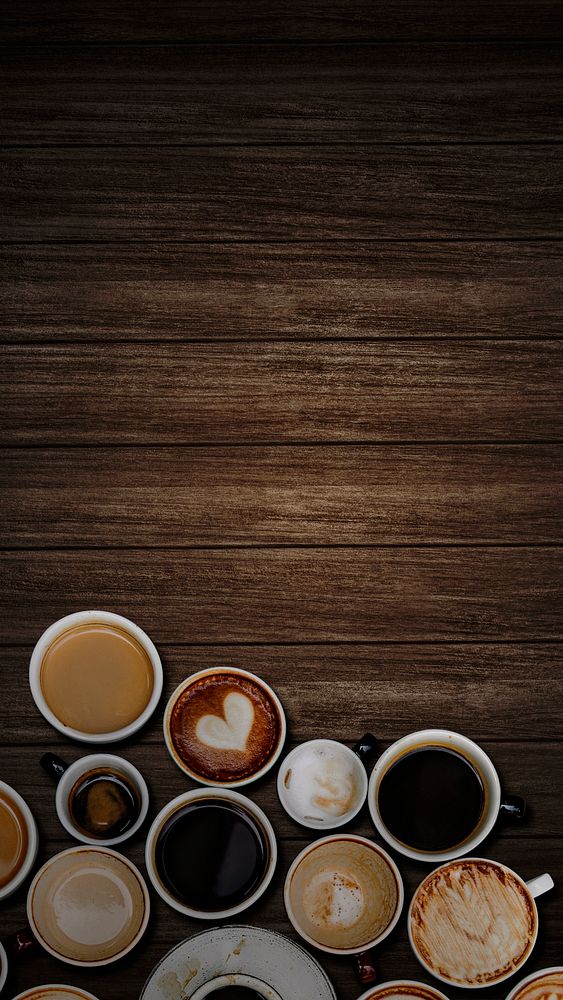 Various coffee cups on a dark brown wooden textured background