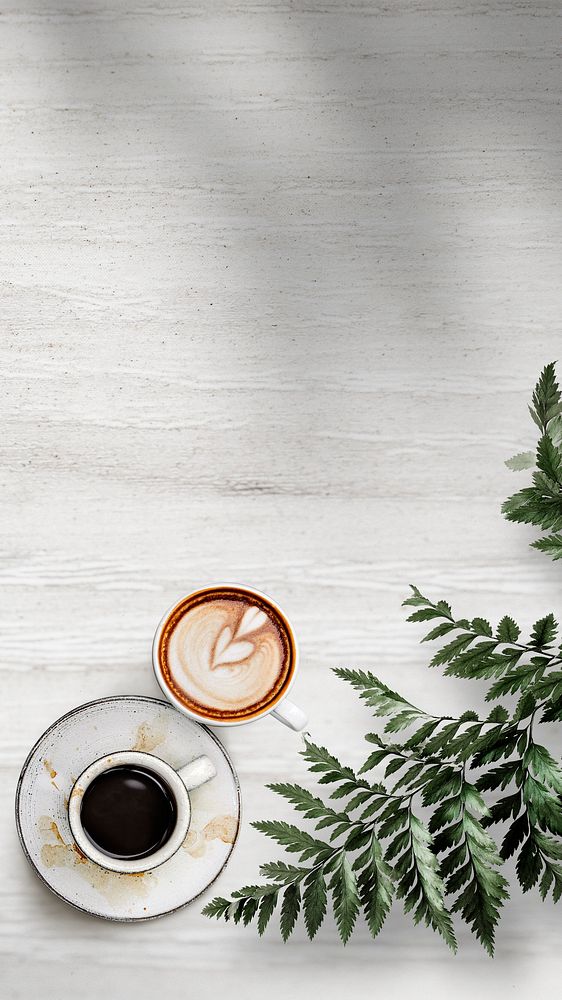 Mixed coffee cups with a leaf on a white wooden textured wallpaper