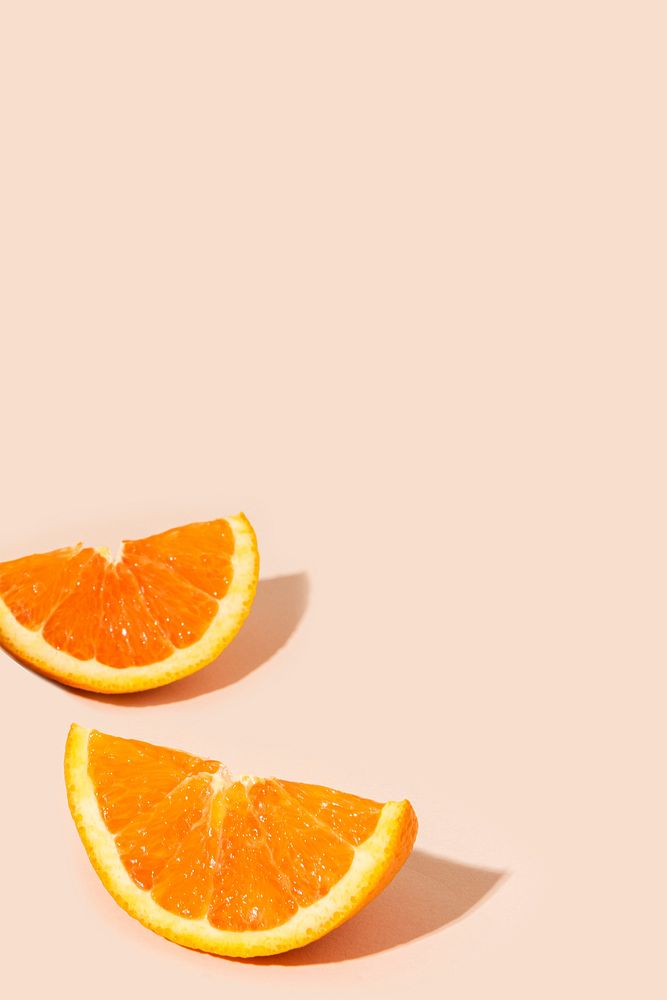 Delicious orange citrus fruit pieces on a light orange background
