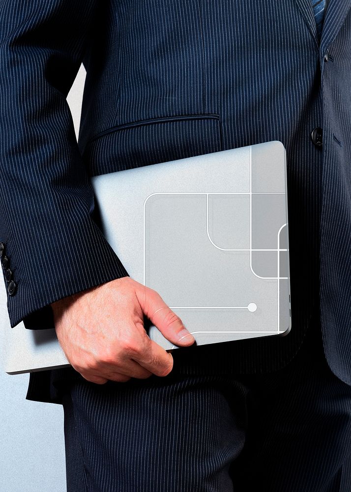 Businessman holding a laptop city background
