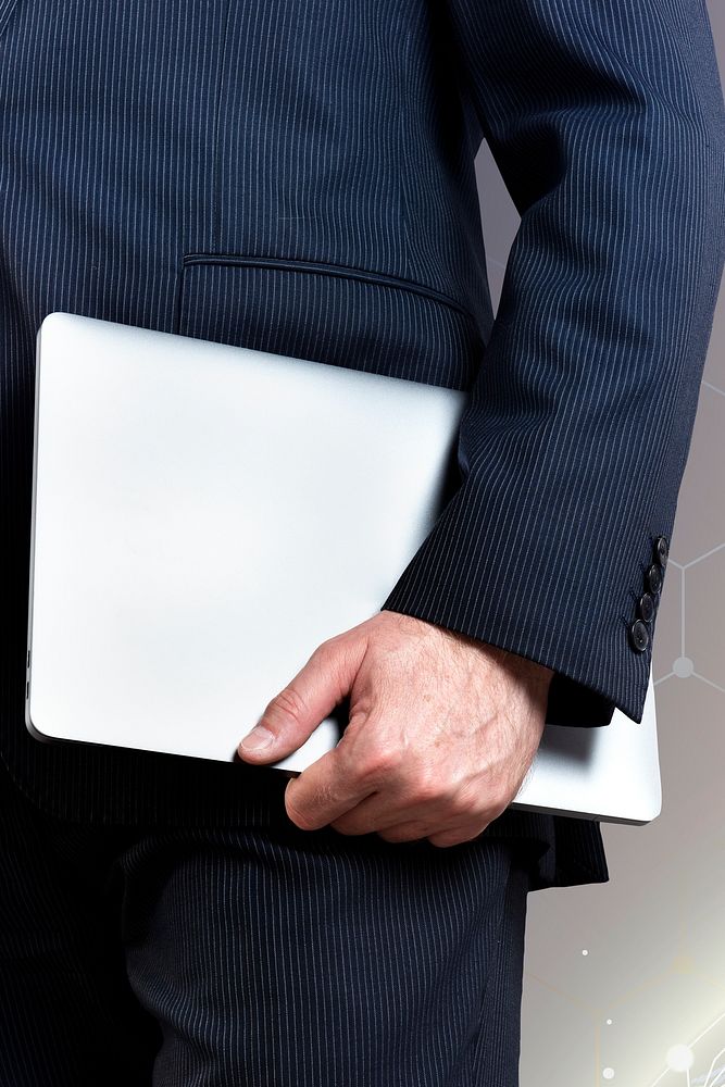Businessman holding his silver laptop