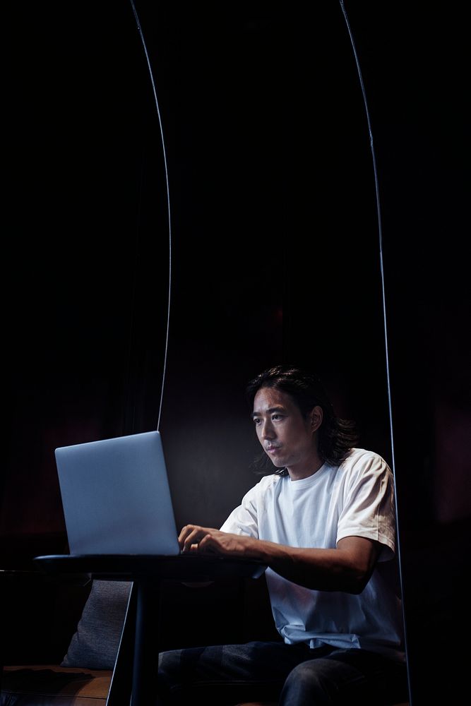 Japanese man working on a laptop at a modern office space
