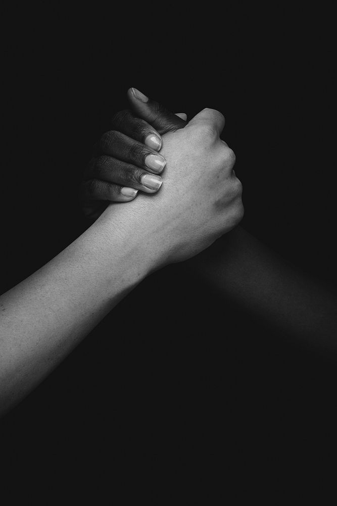 Black and white people holding hands photo closeup