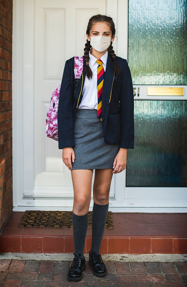 Girl wearing a mask and going to school in the new normal
