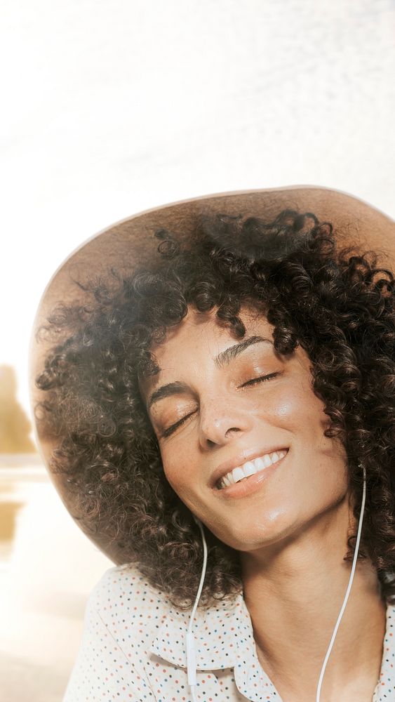 Woman with curly hair wearing earphones with nature view remixed media