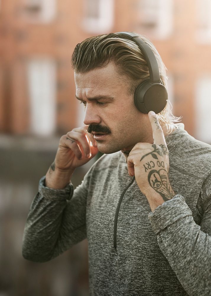 Handsome man wearing wireless headphones remixed media