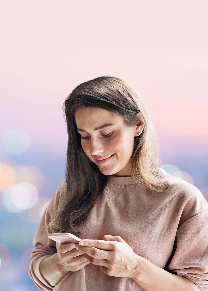 Smiling woman holding smartphone with pastel bokeh lights effect