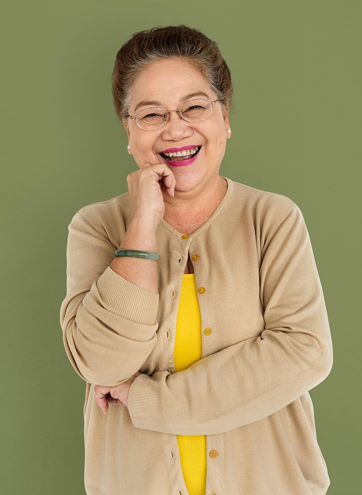 Portrait of a cheerful senior woman touching her chin
