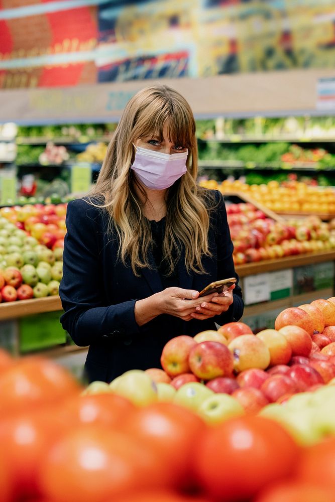 Woman in a face mask while shopping in a supermarket during coronavirus quarantine