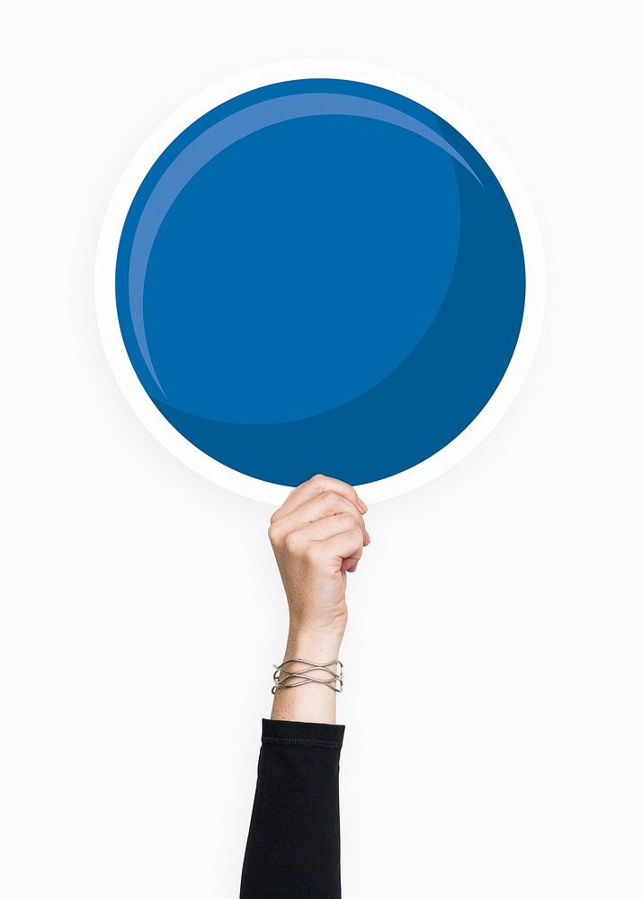 Hand holding a round blue cardboard prop