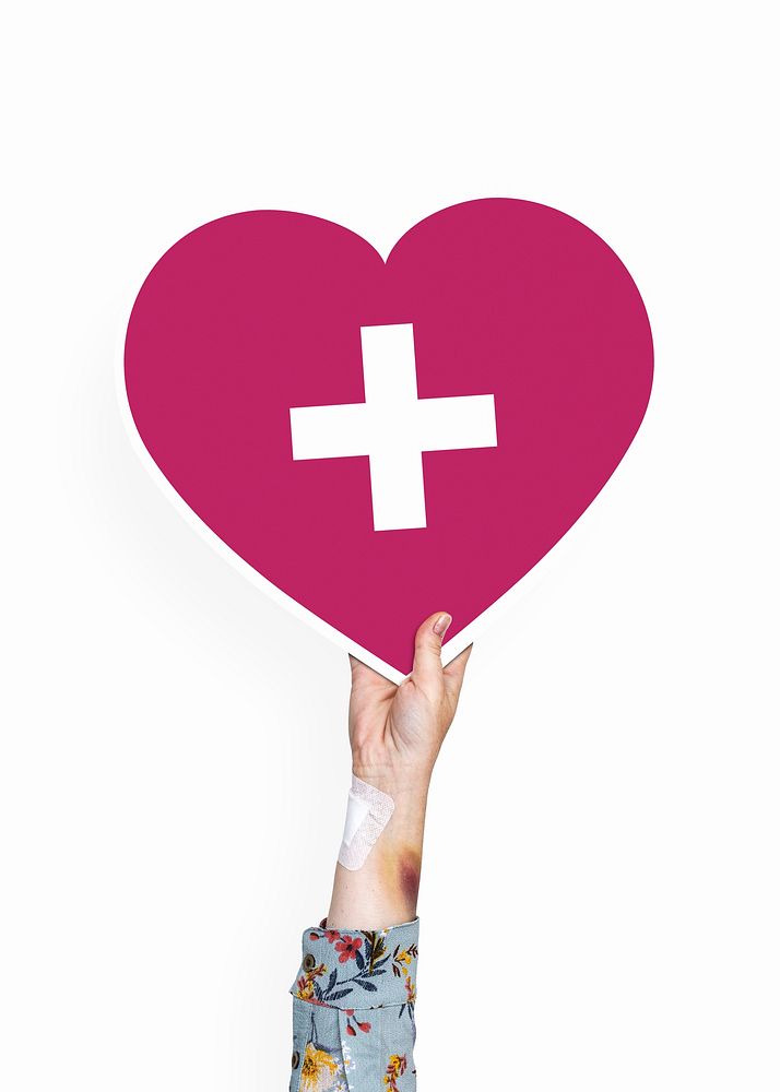Hand holding a heart with a cross cardboard prop