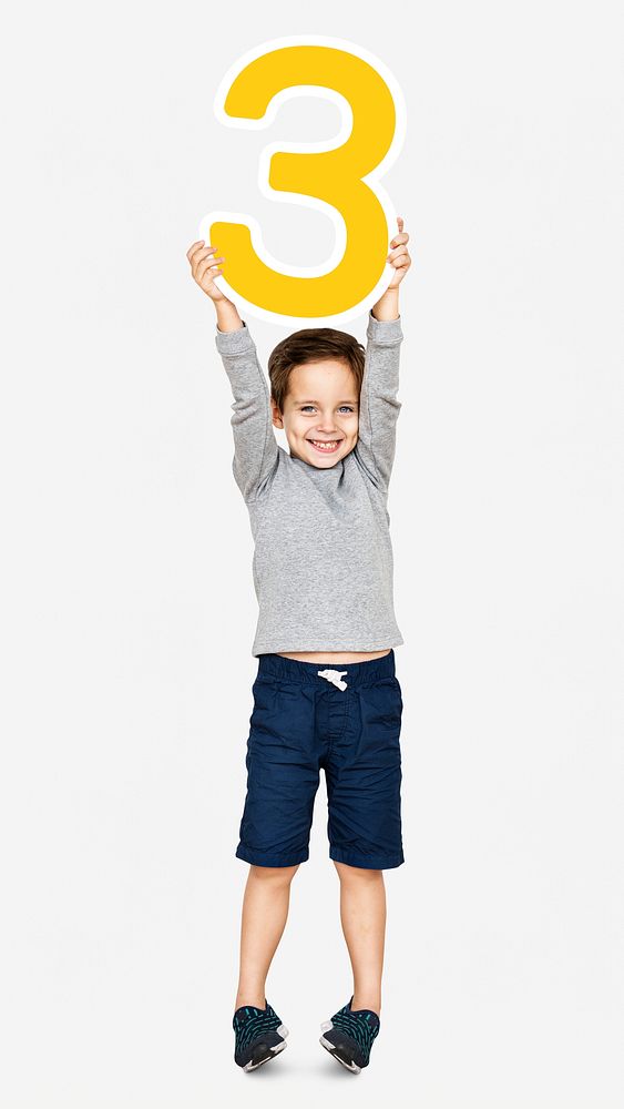 Cheerful boy holding number three