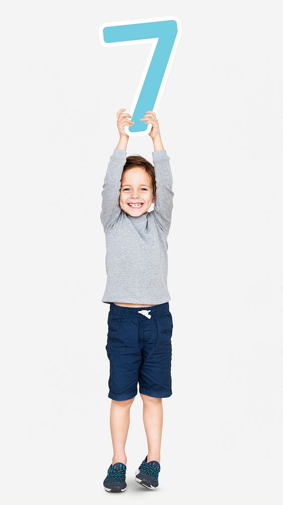 Cheerful boy holding number seven