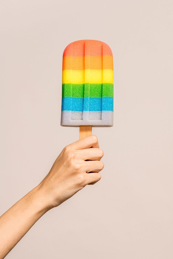 Hand with a rainbow ice pop in summertime