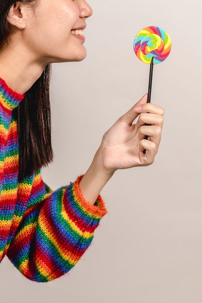 Happy woman with a rainbow lollipop