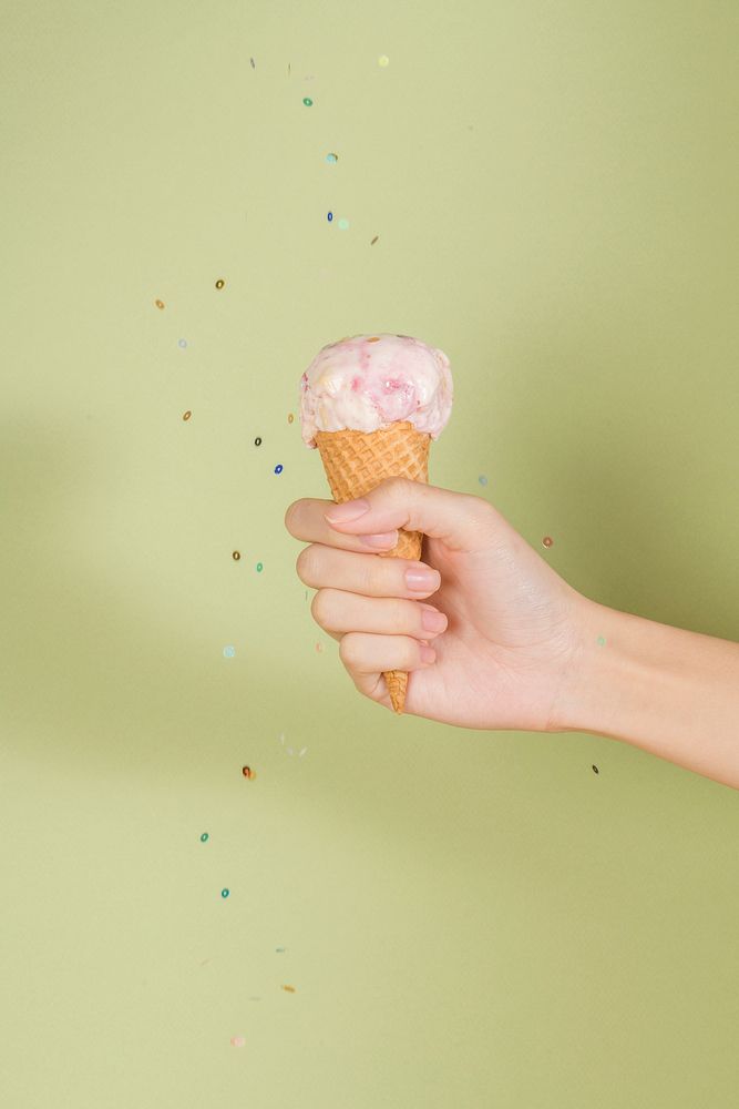 Strawberry ice cream cone in a hand