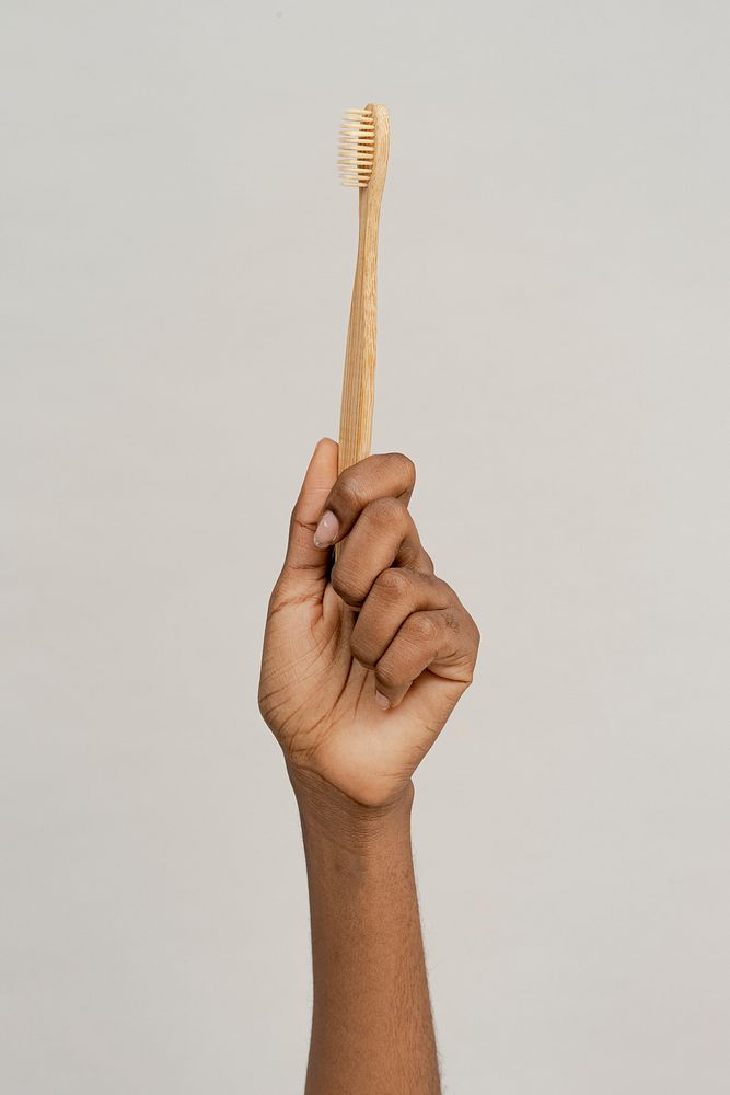 Hand showing a bamboo toothbrush