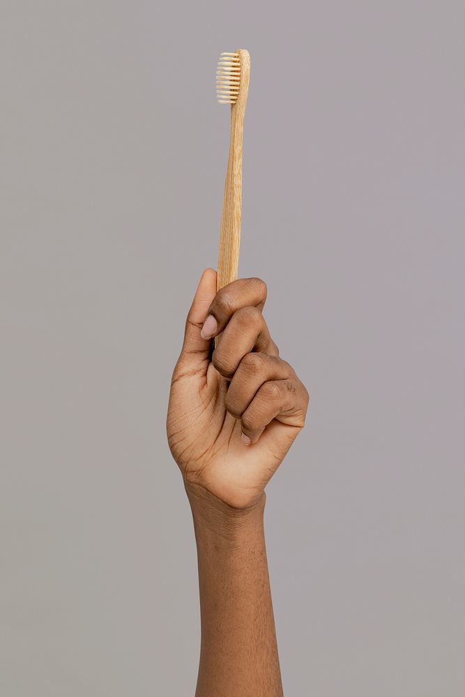 Hand showing a bamboo toothbrush mockup