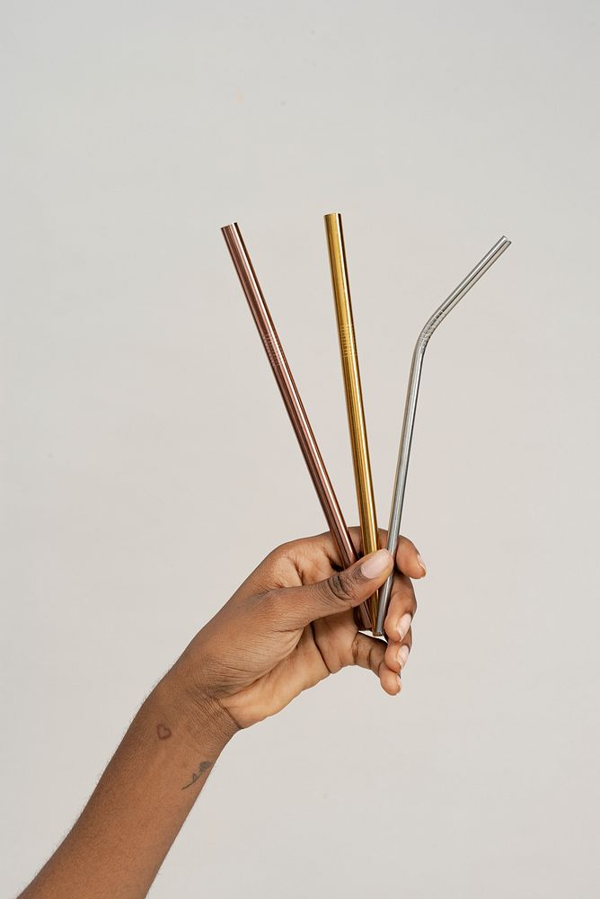 Hand holding reusable metal straws