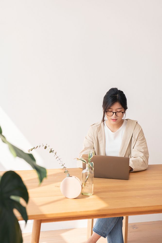 Happy Asian woman working at home using a laptop 