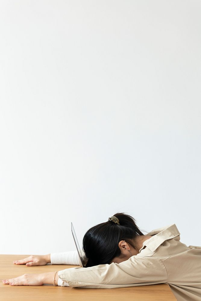 Exhausted Asian girl resting her head on a laptop