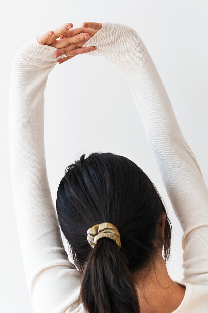 Rear view of a young woman stretching her arms