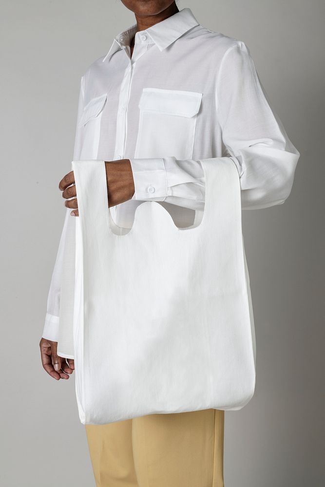 Black woman carrying a white reusable grocery bag mockup 