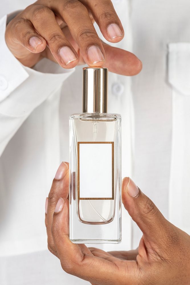 Hands holding blank perfume glass bottle