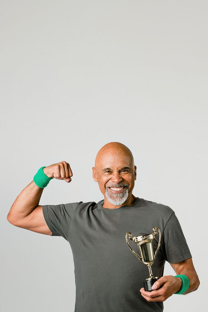 Happy senior man holding a trophy cup